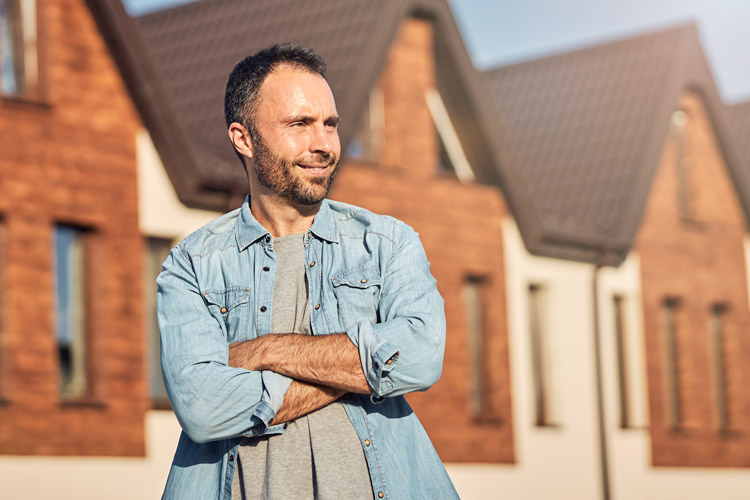 Man standing in front of homes